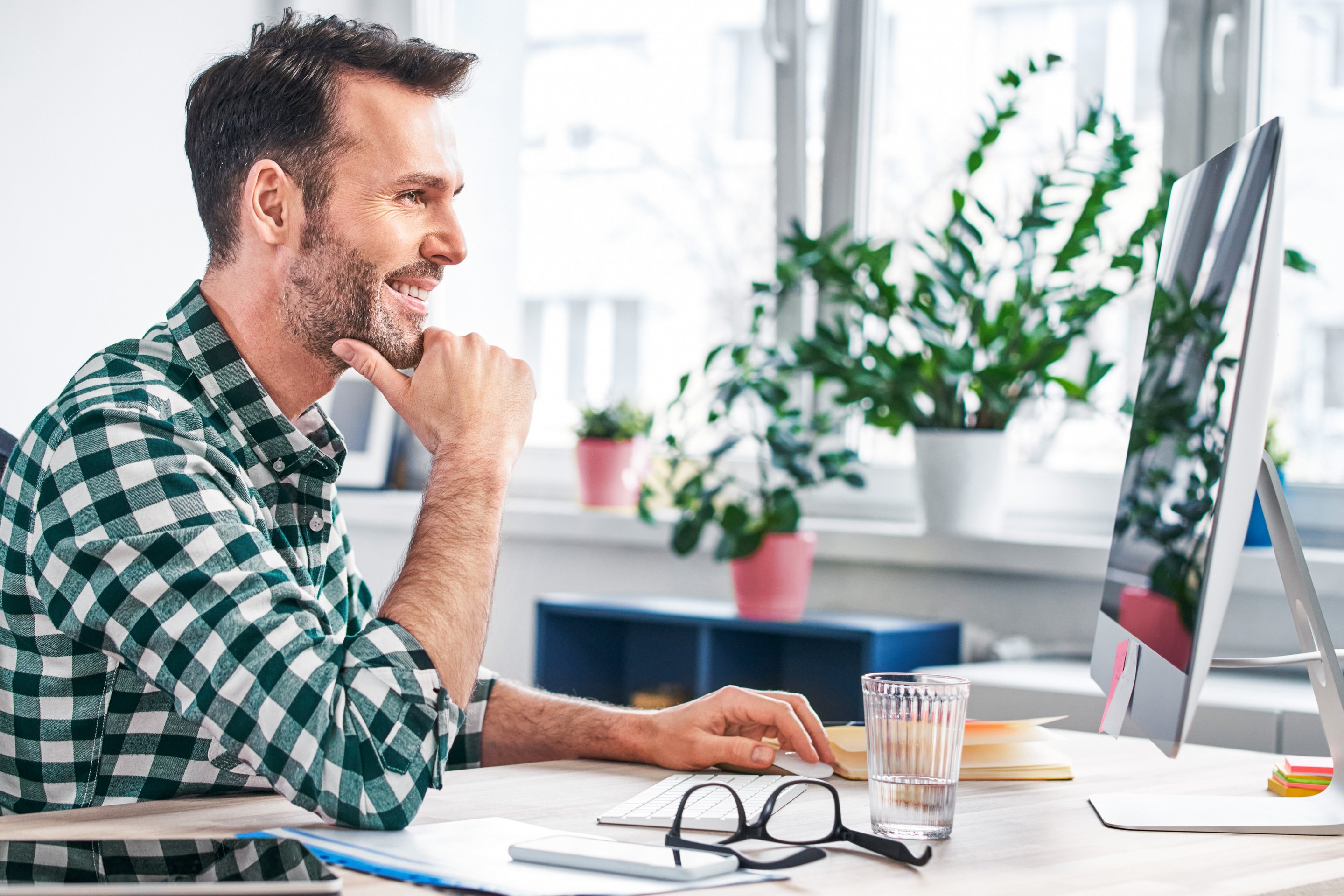 Mann sitzt am Monitor und will eine Webseite erstellen
