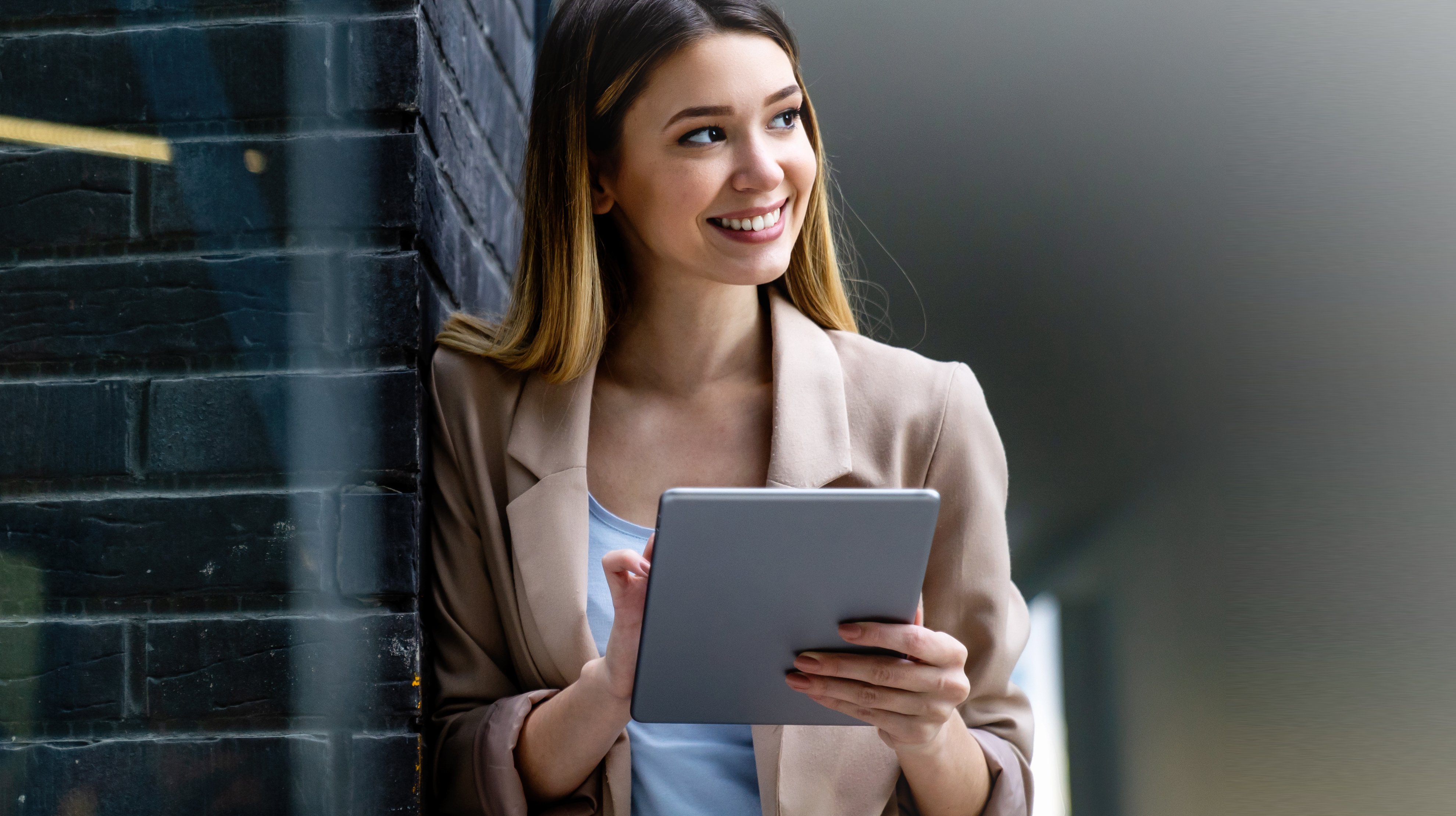 Frau prüft erfreut Ihre E-Mails auf dem Tablet