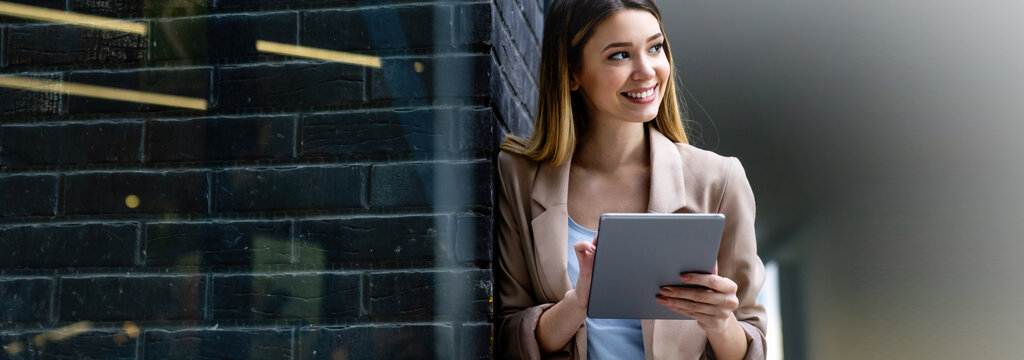 Frau prüft erfreut Ihre E-Mails auf dem Tablet