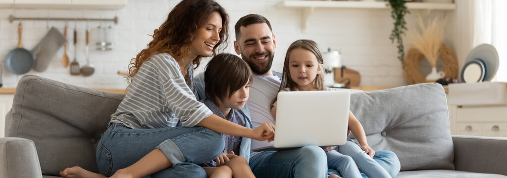 Familie auf Sofa informiert sich über die günstigsten Internet Abos