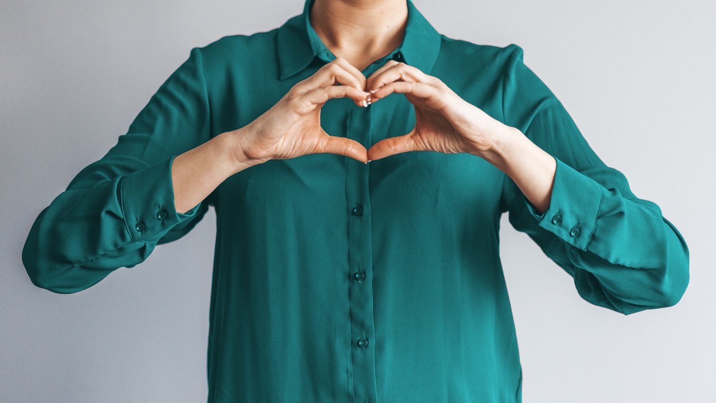 Woman forms a heart with her hands