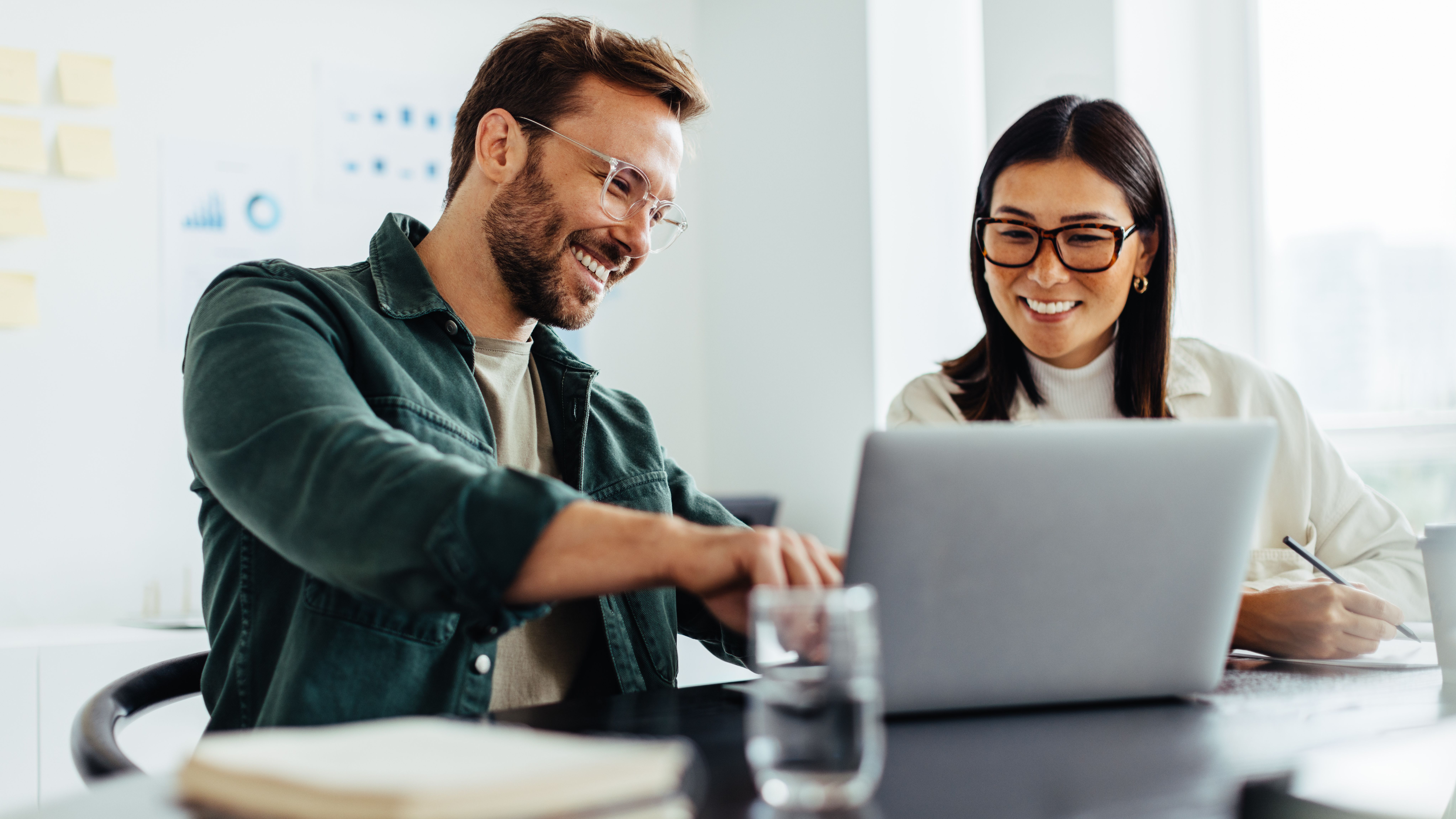 Easily create a website with the Website-Package. A man and a woman discussing something while pointing at a laptop.