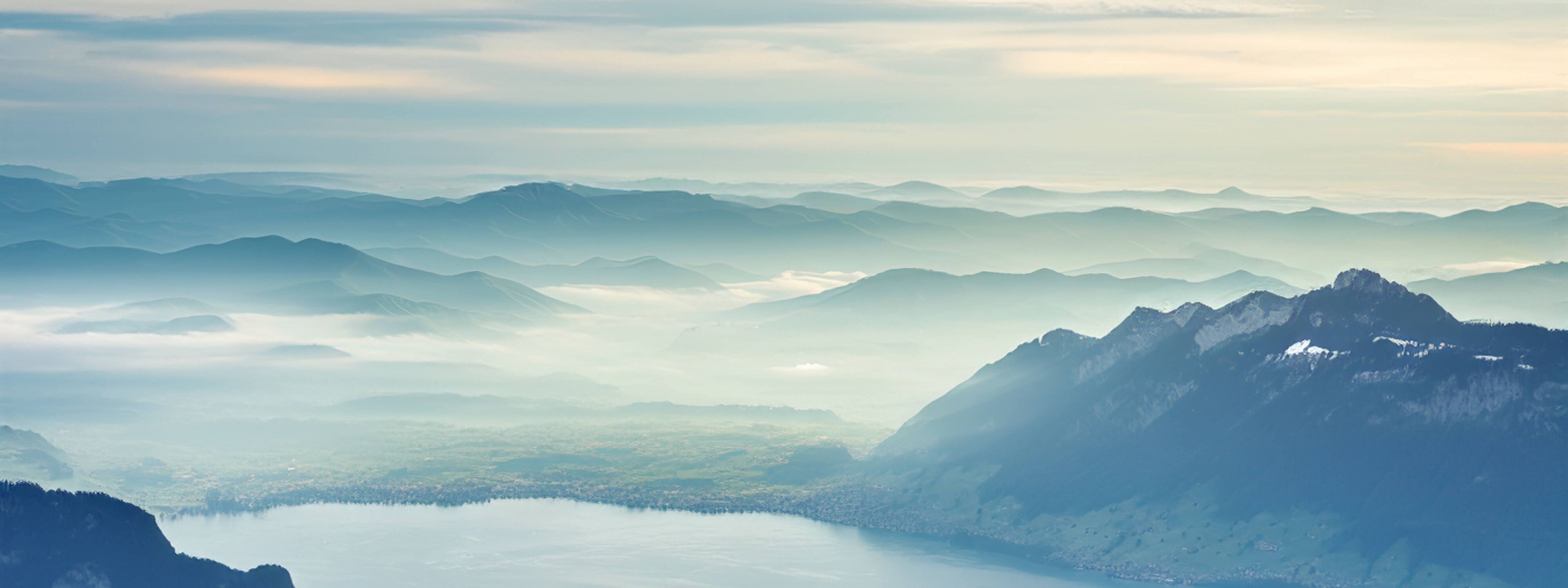 Weitsicht über bewaldete Hügel mit leichten Nebelschwaden