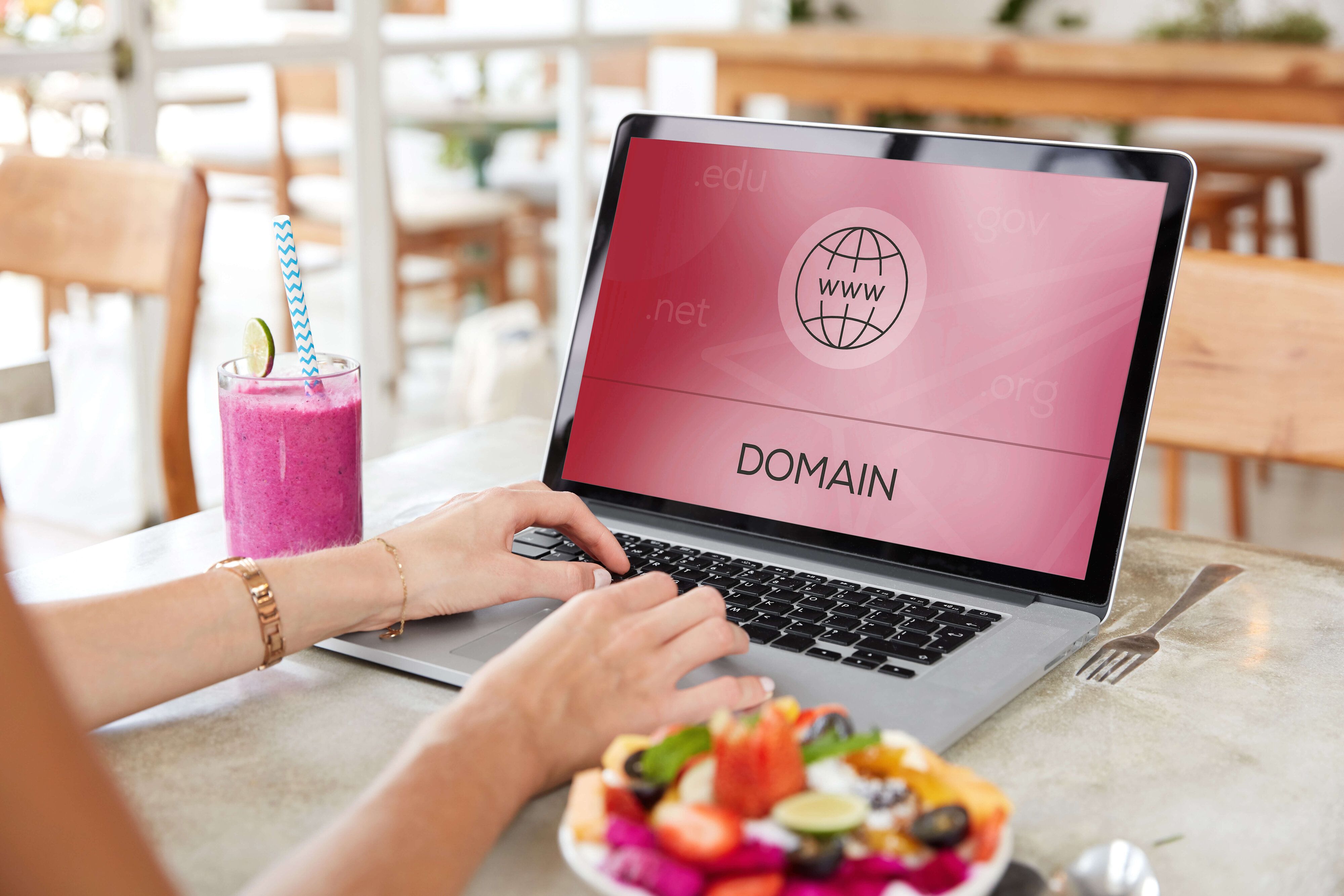 Une femme cherche un nom de domaine pour un site web sur son ordinateur portable