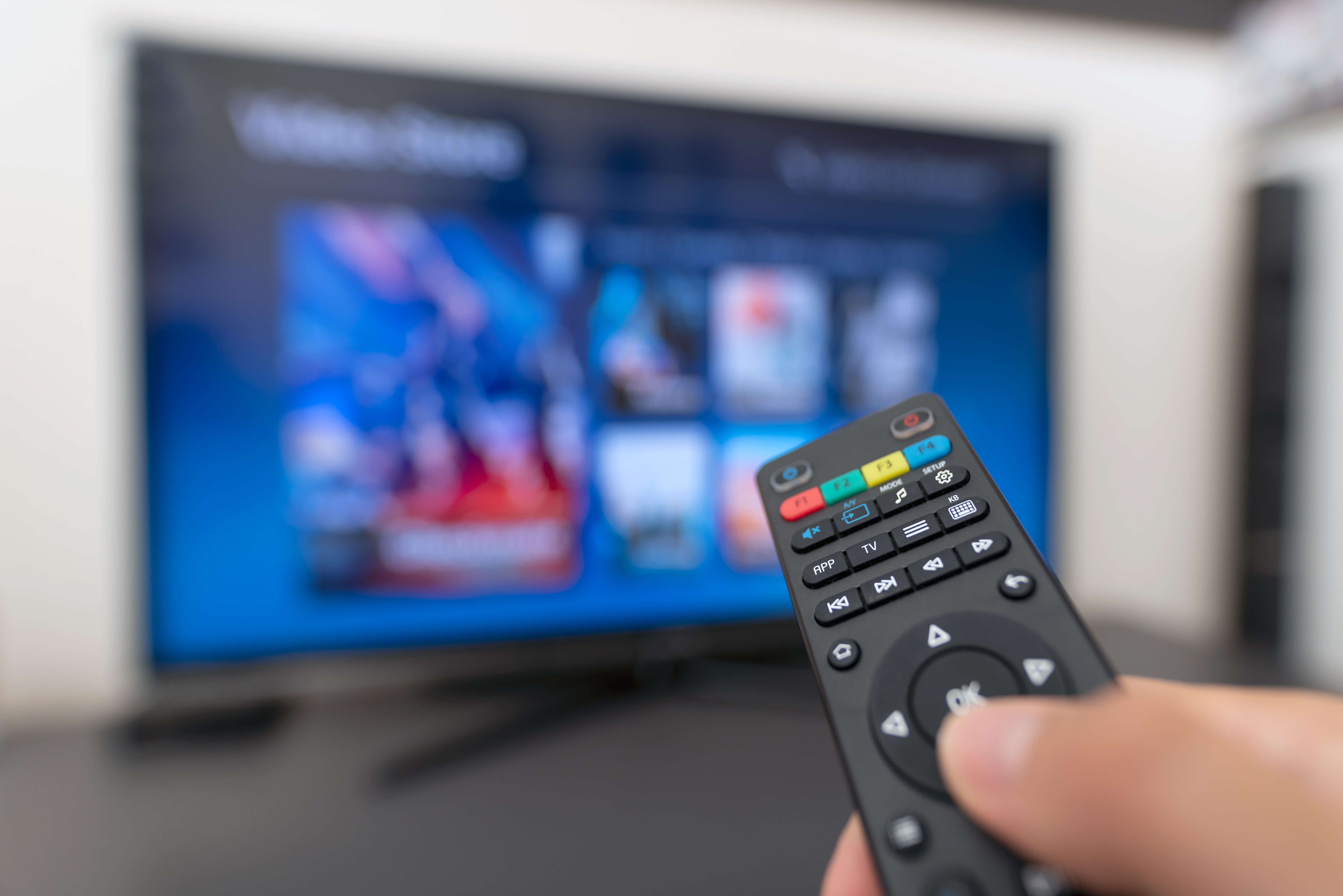 Une personne utilise la télécommande et regarde la TV de Green